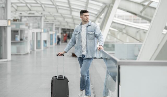 male-passenger-with-travel-suitcase-waiting-for-fl-2023-04-20-20-51-02-utc-min